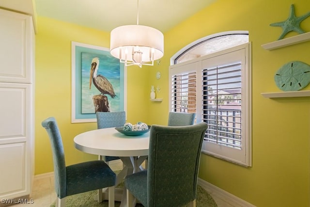 tiled dining room featuring a chandelier