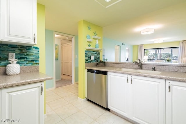 kitchen with light tile patterned flooring, white cabinetry, sink, decorative backsplash, and stainless steel dishwasher