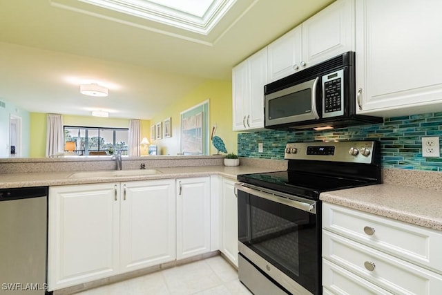 kitchen featuring light tile patterned flooring, sink, tasteful backsplash, stainless steel appliances, and white cabinets