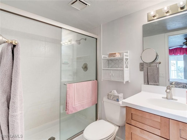 bathroom featuring an enclosed shower, vanity, toilet, and ceiling fan