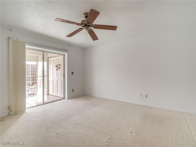 carpeted spare room with ceiling fan