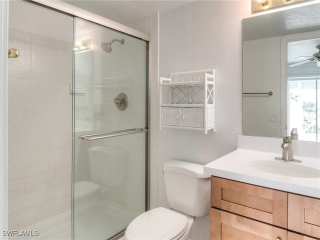 bathroom with vanity, a shower with shower door, ceiling fan, and toilet