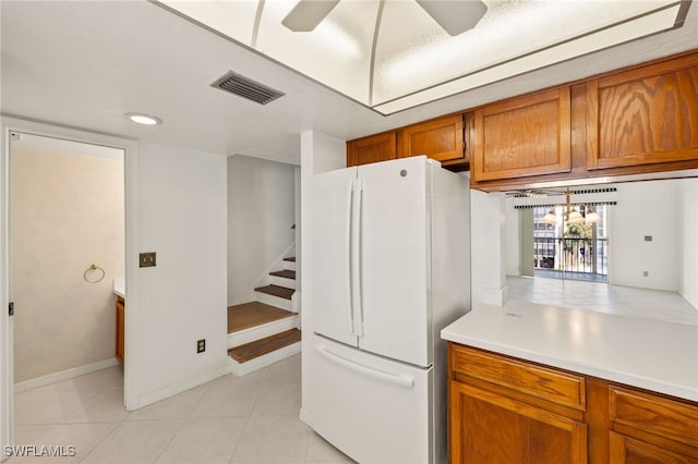 kitchen featuring white refrigerator, ceiling fan, and light tile patterned flooring