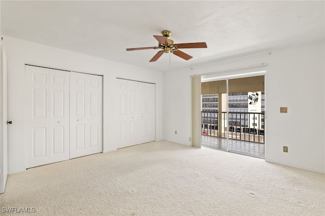 unfurnished bedroom featuring two closets, access to outside, light carpet, and ceiling fan