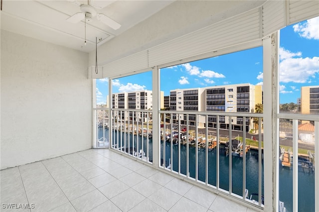 unfurnished sunroom featuring a water view and ceiling fan