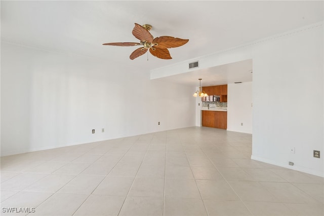 tiled empty room with ornamental molding and ceiling fan with notable chandelier