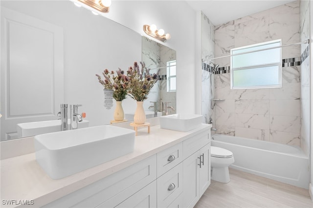 full bathroom featuring vanity, toilet, and tiled shower / bath