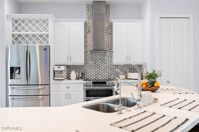 kitchen featuring decorative backsplash, stainless steel appliances, white cabinetry, and wall chimney exhaust hood