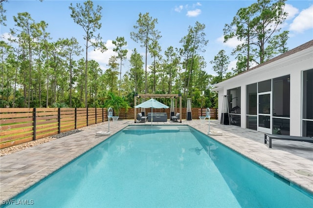 view of swimming pool featuring a pergola, a patio, a hot tub, and a sunroom