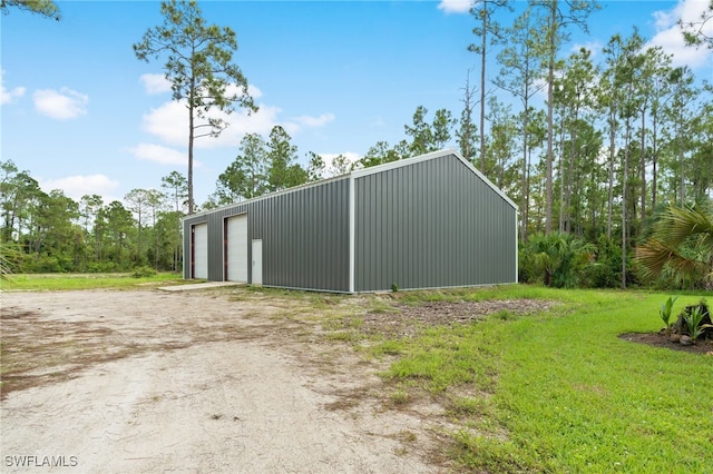 view of outdoor structure featuring a lawn and a garage