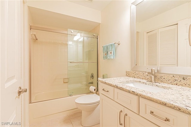 full bathroom featuring tile patterned flooring, vanity, combined bath / shower with glass door, and toilet