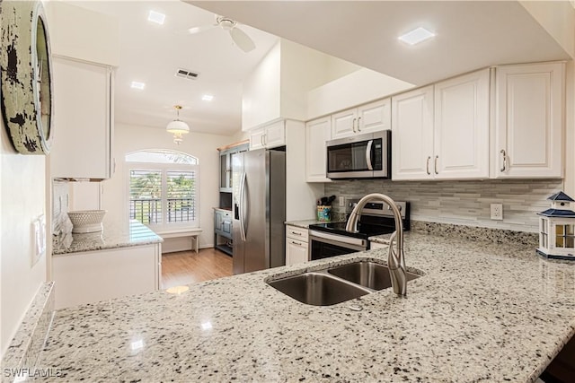 kitchen featuring light stone counters, hanging light fixtures, stainless steel appliances, and white cabinets