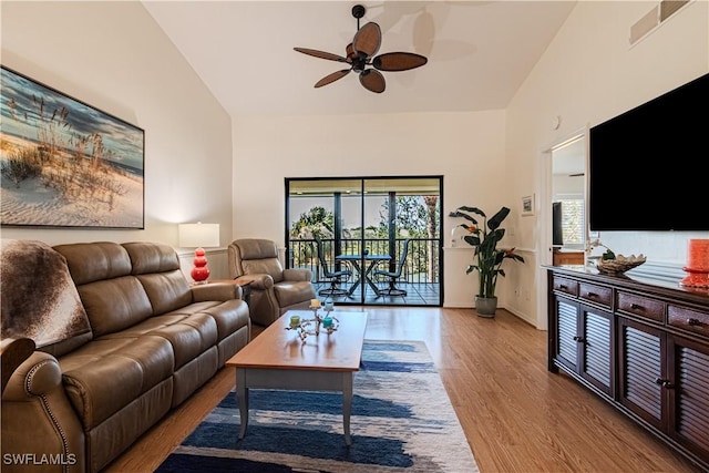 living room with high vaulted ceiling, ceiling fan, and light hardwood / wood-style flooring