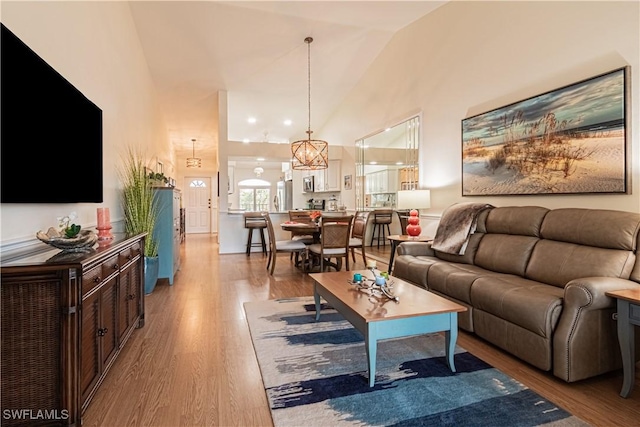 living room with high vaulted ceiling and light hardwood / wood-style floors