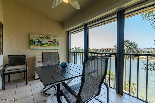 sunroom featuring a water view, lofted ceiling, and ceiling fan