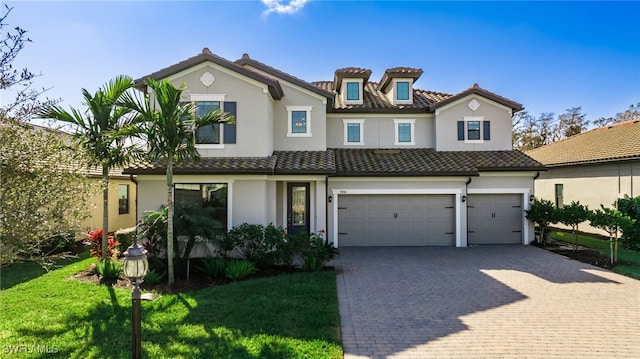 mediterranean / spanish house with a garage and a front lawn