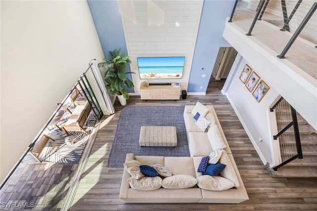 living room featuring dark hardwood / wood-style flooring and a towering ceiling