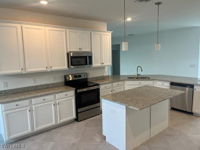 kitchen featuring white cabinetry, sink, hanging light fixtures, a kitchen island, and appliances with stainless steel finishes