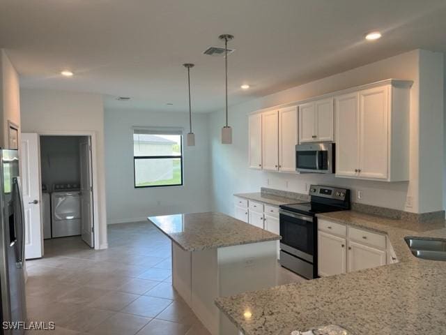 kitchen featuring white cabinetry, a center island, stainless steel appliances, light stone counters, and decorative light fixtures