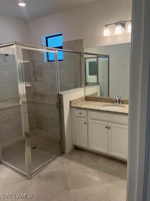 bathroom with vanity, tile patterned floors, and a shower with door