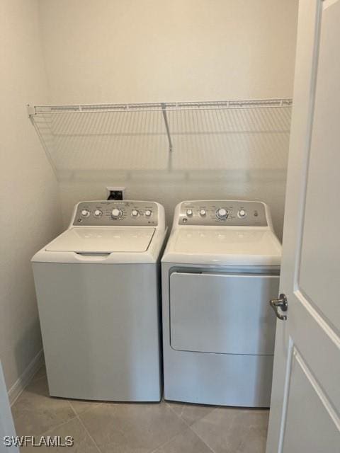 laundry area featuring light tile patterned floors and washing machine and clothes dryer