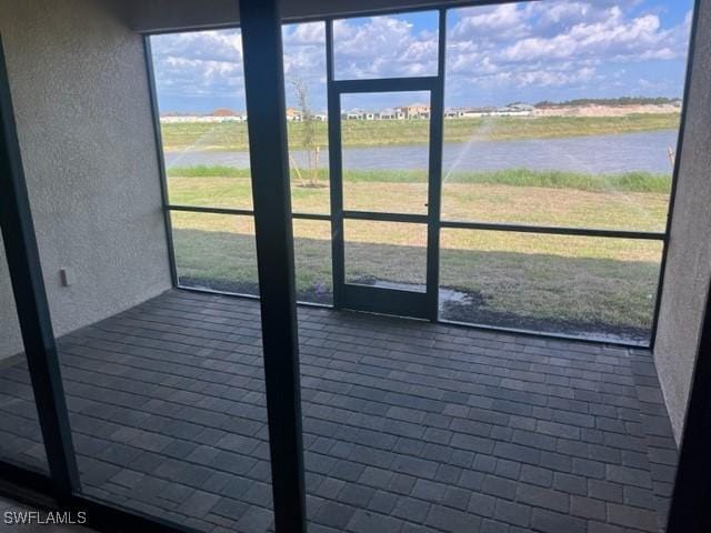 unfurnished sunroom featuring a water view and plenty of natural light