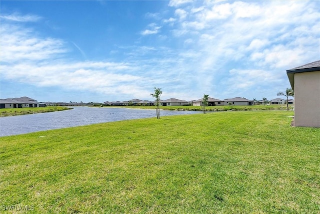view of yard featuring a residential view and a water view