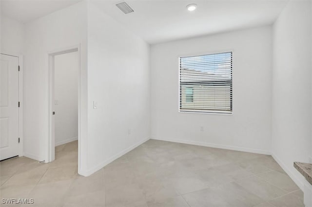spare room with baseboards and visible vents