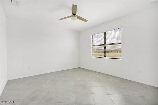 spare room with visible vents, a ceiling fan, baseboards, and light tile patterned floors