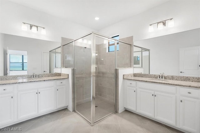 full bath with tile patterned flooring, a sink, and a stall shower
