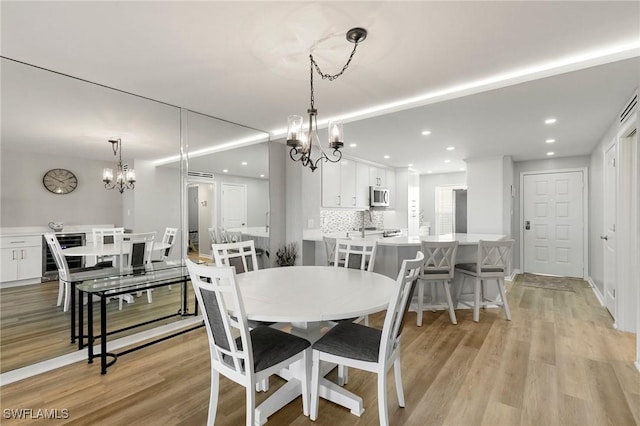 dining area featuring a notable chandelier and light wood-type flooring