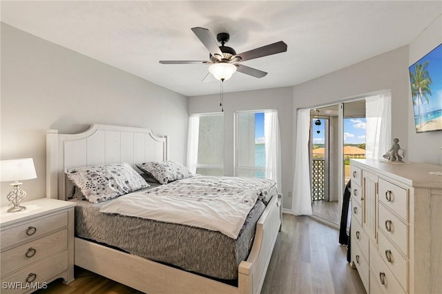 bedroom featuring access to exterior, ceiling fan, and dark wood-type flooring