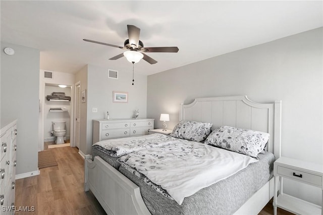 bedroom with ceiling fan, wood-type flooring, and ensuite bath