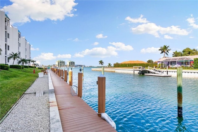 view of dock with a water view and a yard