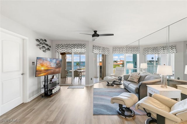 living room with light hardwood / wood-style flooring, a wealth of natural light, and ceiling fan