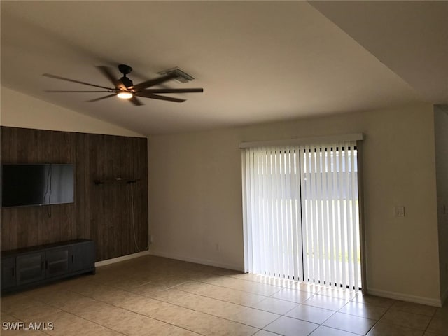 unfurnished living room with ceiling fan, light tile patterned floors, and vaulted ceiling