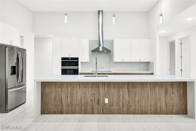 kitchen featuring white cabinets, stainless steel refrigerator with ice dispenser, decorative backsplash, double oven, and decorative light fixtures