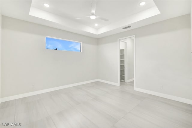 unfurnished room featuring a tray ceiling and ceiling fan