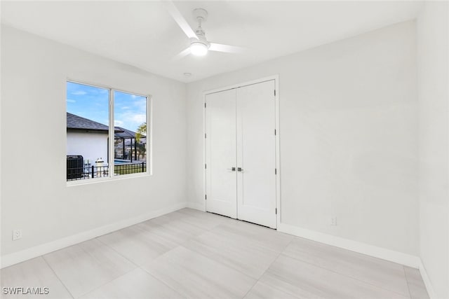 unfurnished bedroom with light tile patterned floors, a closet, and ceiling fan