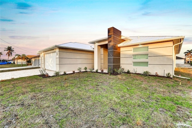 view of front facade with a lawn and a garage