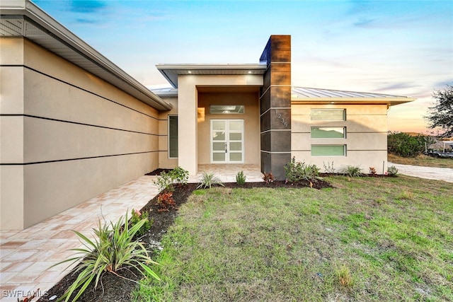 exterior entry at dusk with a lawn