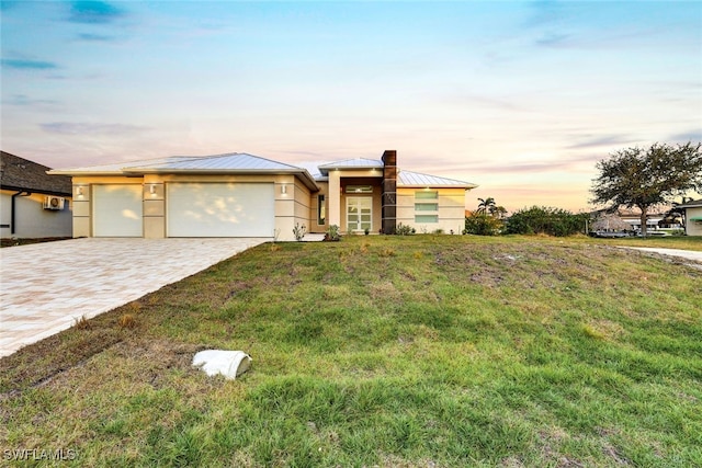 ranch-style house featuring a yard and a garage