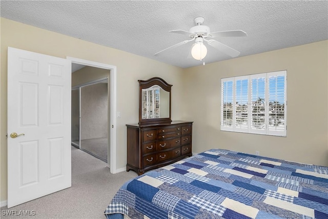 carpeted bedroom with ceiling fan, a textured ceiling, and a closet