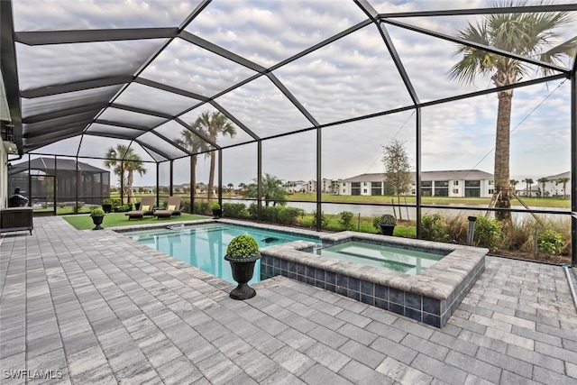 view of pool featuring an in ground hot tub, a patio, a water view, and glass enclosure