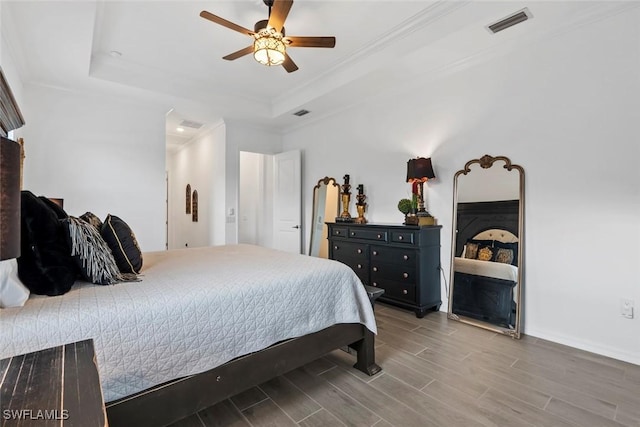 bedroom featuring a raised ceiling, ceiling fan, and crown molding