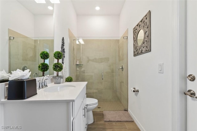 bathroom with vanity, toilet, and a shower with shower door