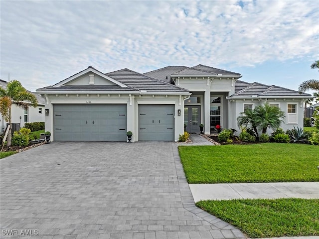 view of front of property with french doors, a front yard, and a garage