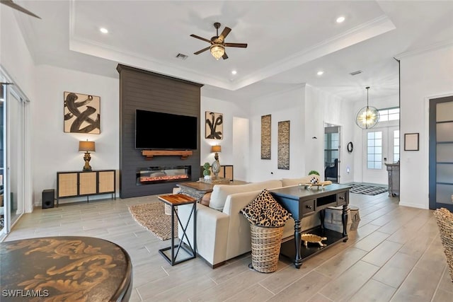 living room featuring a raised ceiling, ceiling fan, and french doors