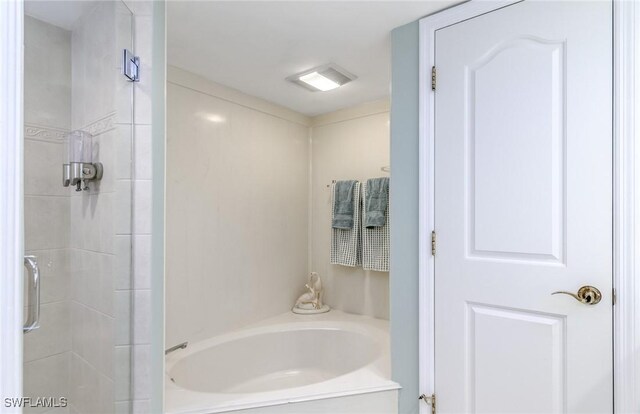 bathroom featuring a garden tub and a shower stall