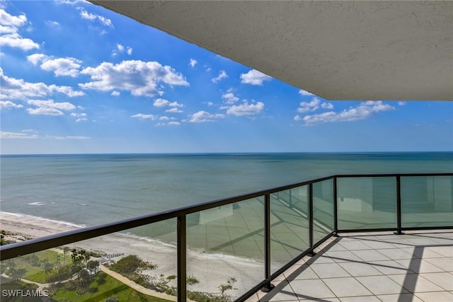 balcony with a water view and a beach view